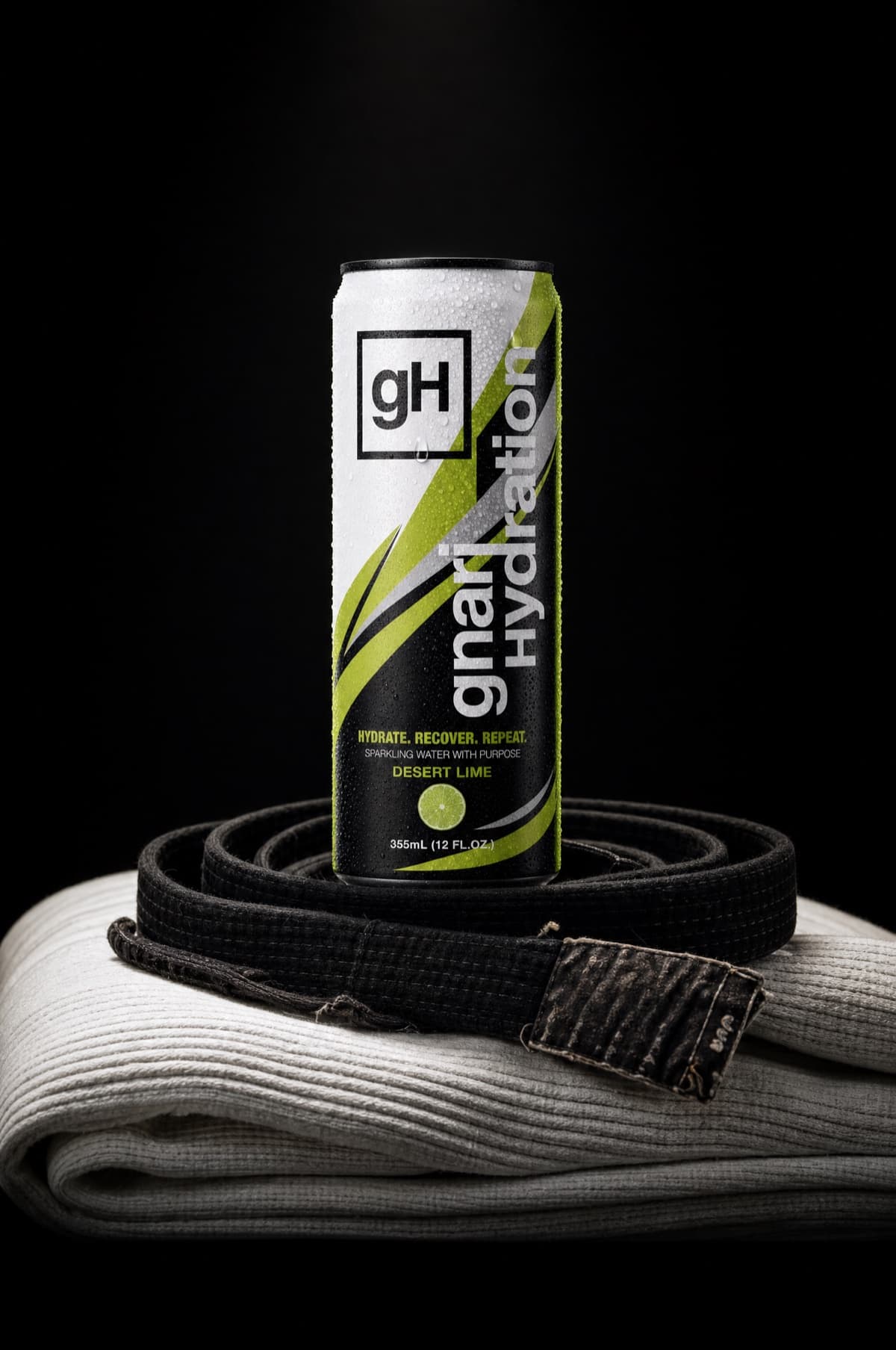 GH001 Desert Lime — can standing on a folded gi with a black belt coiled at its base